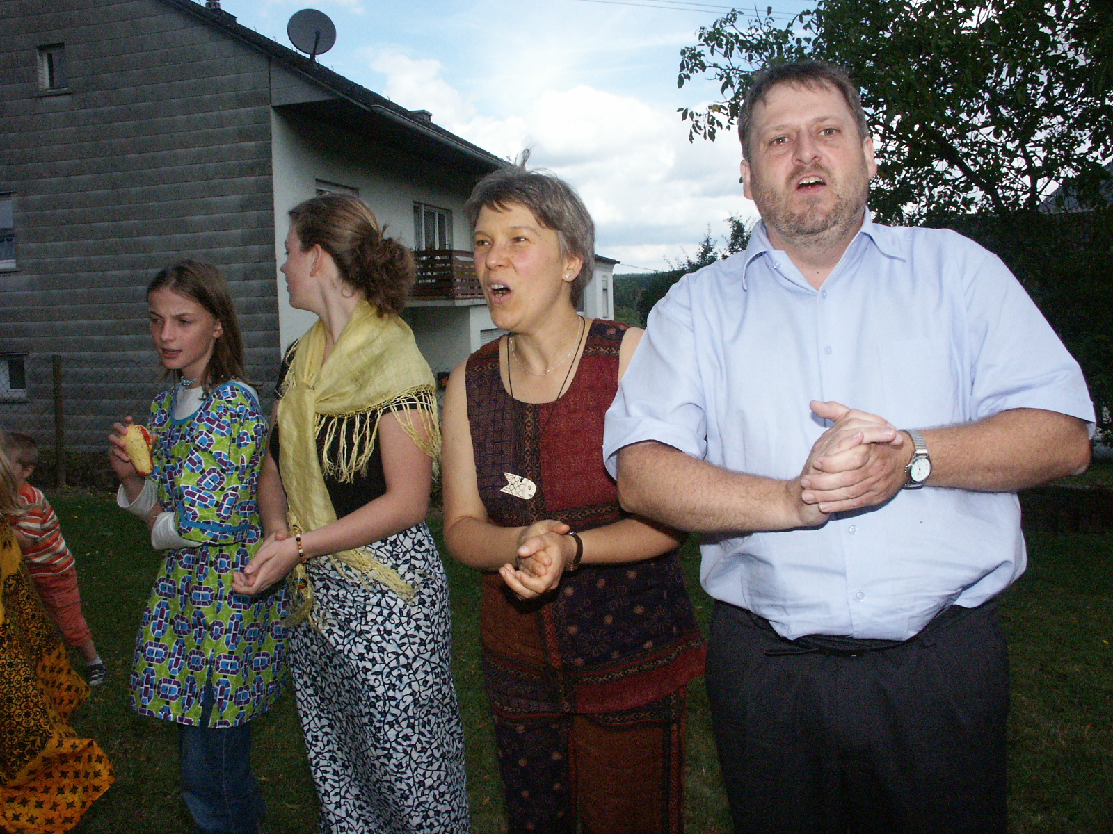 Der damalige Gemeindepfarrer Ulrich Müller (rechts) zum Abschluss eines Gottesdienstes in Raversbeuren im Rahmen eines Partnerschafsbesuchs aus Botswana 2005. Man verabschiedet sich in einer langen Schlange singend und mit gegenseitigem Händedruck, einer Gepflogenheit aus dem Partnerland Botswana folgend, voneinander.